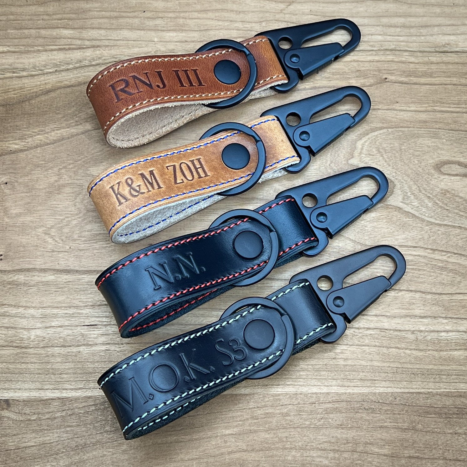 Four Custom Tactical Keychains in Horween leather with colored stitching and heatstamped personalization and monograms.